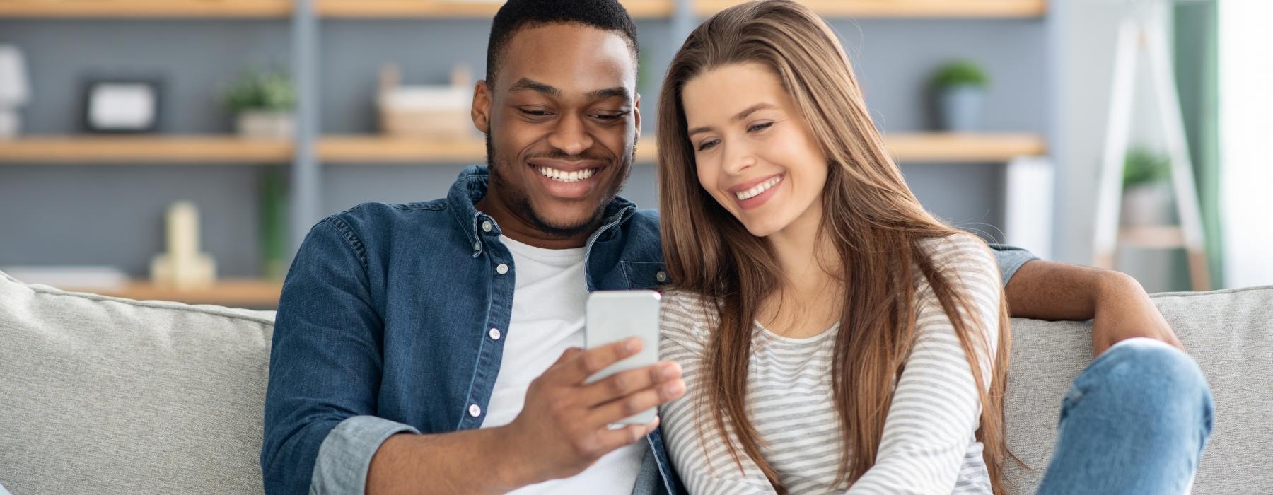 a man and a woman sitting on a couch and smiling