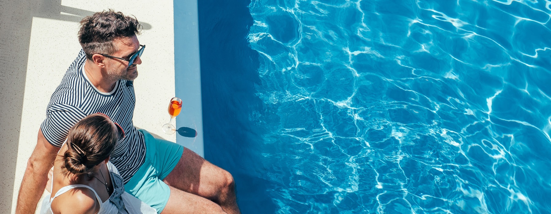 a couple sitting by a pool