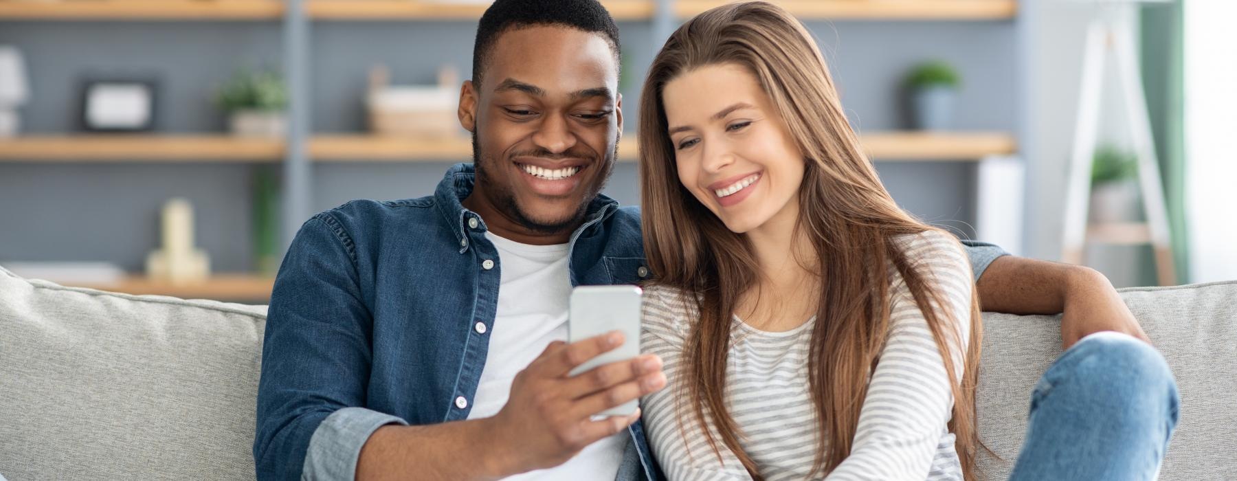 a man and a woman sitting on a couch and smiling