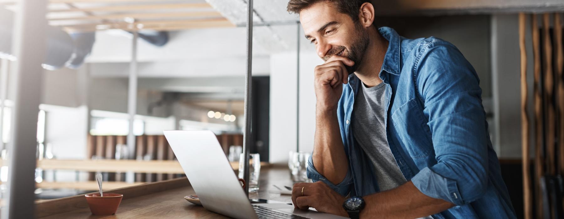 a man sitting at a desk with a laptop